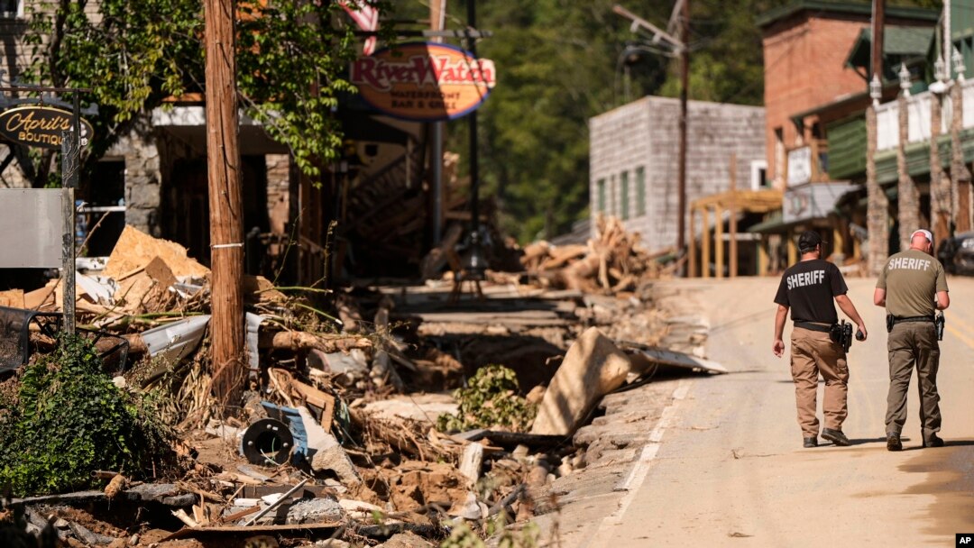 Dos agentes del sheriff caminan por la calle principal después del paso del huracán Helene, el miércoles 2 de octubre de 2024, en Chimney Rock Village, Carolina del Norte