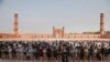 FILE - Small numbers of people offer Friday prayers at the grand Badshahi mosque, due to coronavirus outbreak, in Lahore, Pakistan, March 20, 2020.
