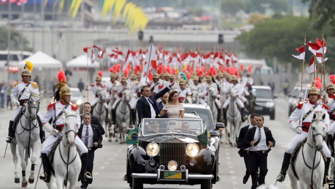 Junto a la primera dama, Michelle Bolsonaro, el presidente de Brasil Jair Bolsonaro saluda a los asistentes a su ceremonia de posesión en Brasilia, Brasil, el martes 1 de enero del 2019
