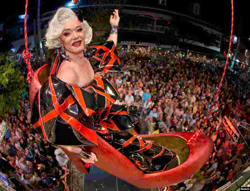 Gary Marion, also known as drag queen Sushi, hangs in an oversized replica of a women&#39;s red high heel during New Year&#39;s Eve celebrations on Duval Street at the Bourbon St. Pub in Key West, Florida, Dec. 31, 2018.