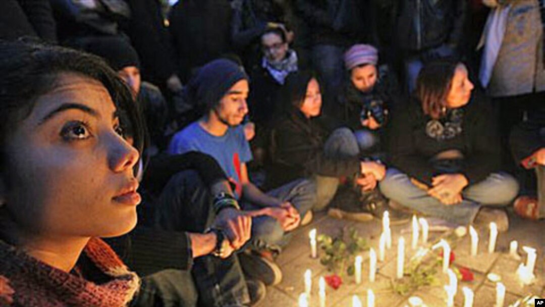 Young people gather around candles as they begin three days of mourning Friday to mourn dozens who died in the protests that drove their autocratic leader from power, in Tunis, January 22, 2011