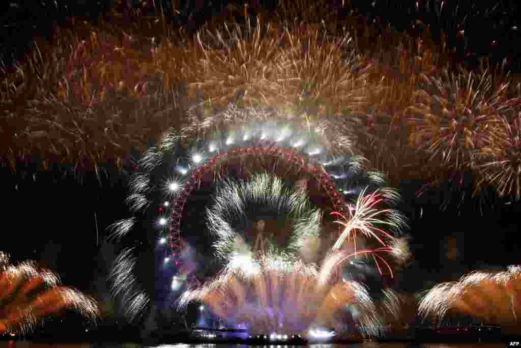 Fireworks explode around the London Eye during New Year&#39;s celebrations in central London just after midnight.