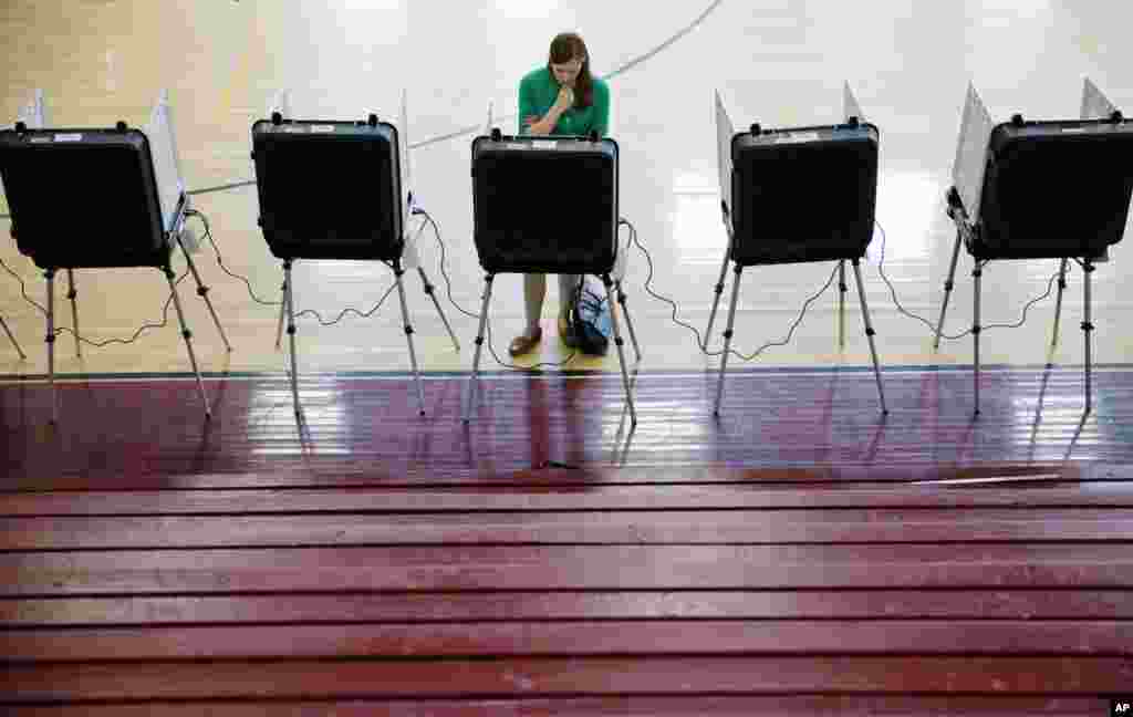 A voter casts a ballot in Georgia's primary election at a polling site in a high school gymnasium, March 1, 2016, in Atlanta.
