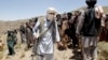 FILE - Members of a Taliban breakaway faction walk during a gathering, in Shindand district of Herat province, Afghanistan, May 27, 2016.