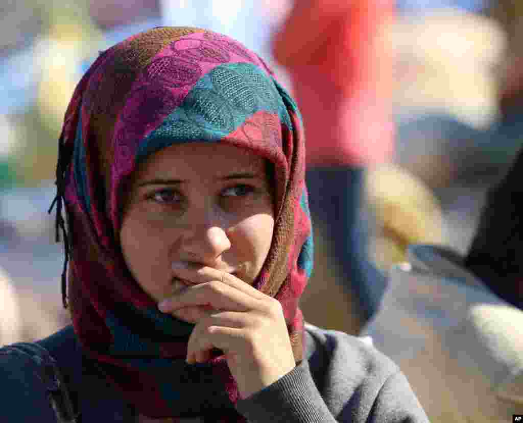 A Syrian refugee waits for transport after arriving at the Turkey-Syria border near Suruc, Turkey, Sept. 30, 2014.