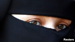 FILE - A protestor attends a demonstration against the ban on Muslim women wearing the burqa in public in The Hague, Netherlands.