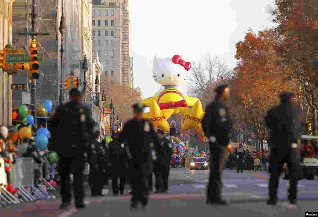 2012年11月22日，警察走在纽约中央公园西侧，同时，Hello Kitty气球等待着梅西第86届花车游行的开始。