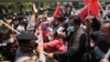 Activists scuffle with police officers as they are dispersed during a rally against Myanmar's military coup near the Association of Southeast Asian Nations (ASEAN) Secretariat ahead of a leaders' meeting in Jakarta, Indonesia, Saturday, April 24,…