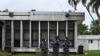 FILE - Police officers wearing face masks stands outside the Pasteur Institute of Ivory Coast, near Abidjan, May 11, 2020.