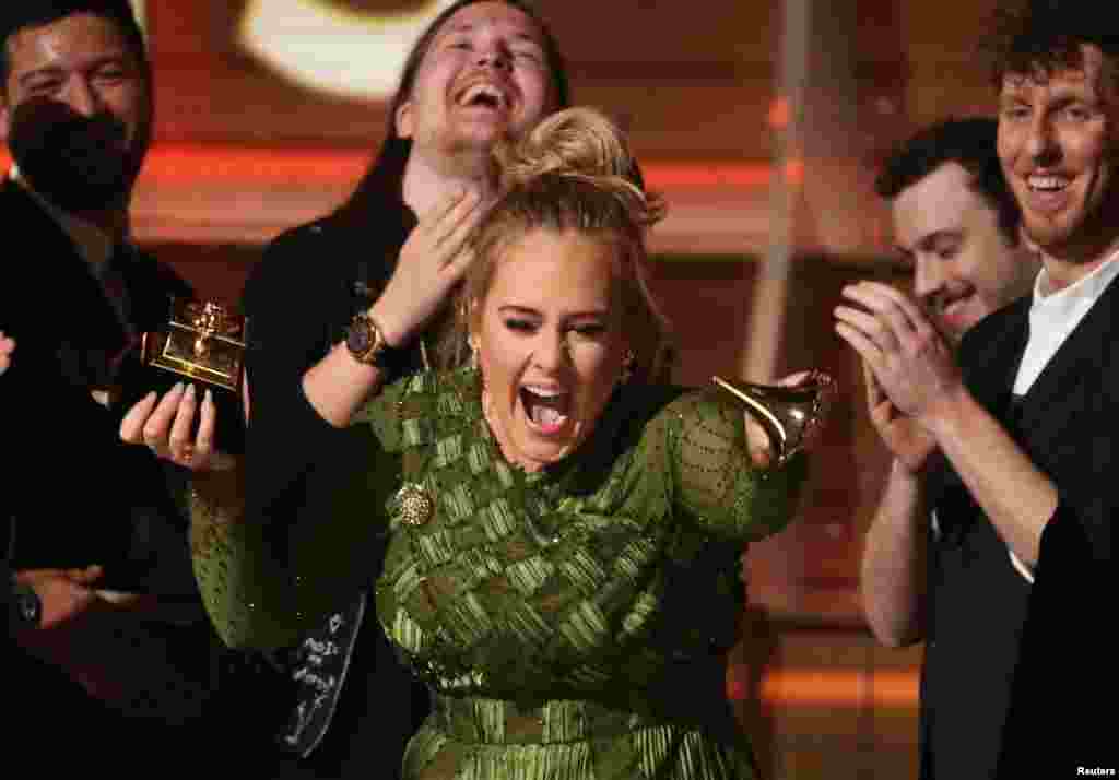 Adele breaks the Grammy for Record of the Year for &quot;Hello&quot; after having it presented to her at the 59th Annual Grammy Awards in Los Angeles, California, Feb. 12, 2017.