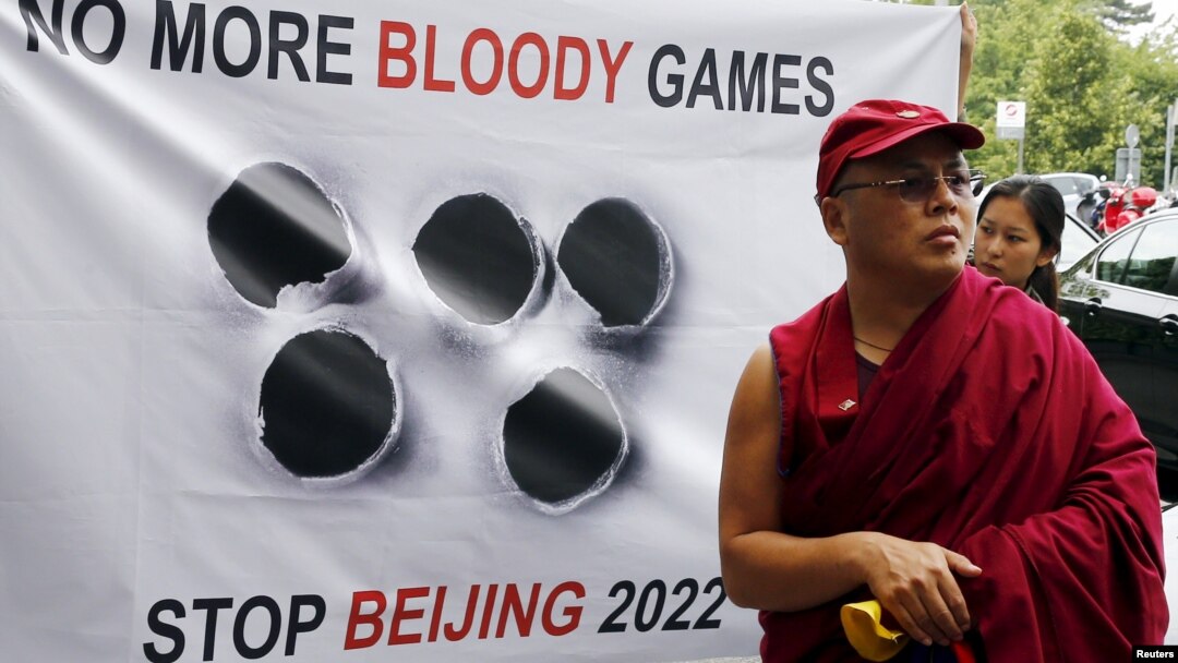 FILE - A Tibetan monk stands in front of a banner outside the Beijing 2022 Winter Olympic Games Bid presentation at the Palace Hotel in Lausanne, Switzerland June 10, 2015.