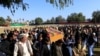 Afghan men pray near the coffin of journalist Malalai Maiwand, who was shot and killed by unknown gunmen in Jalalabad, Afghanistan, Dec. 10, 2020.