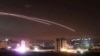 FILE - This photo provided by the government-controlled Syrian Central Military Media shows missiles rise into the sky as Israeli airstrikes hit air defense positions and other military bases, in Damascus, Syria, in May 2018. 