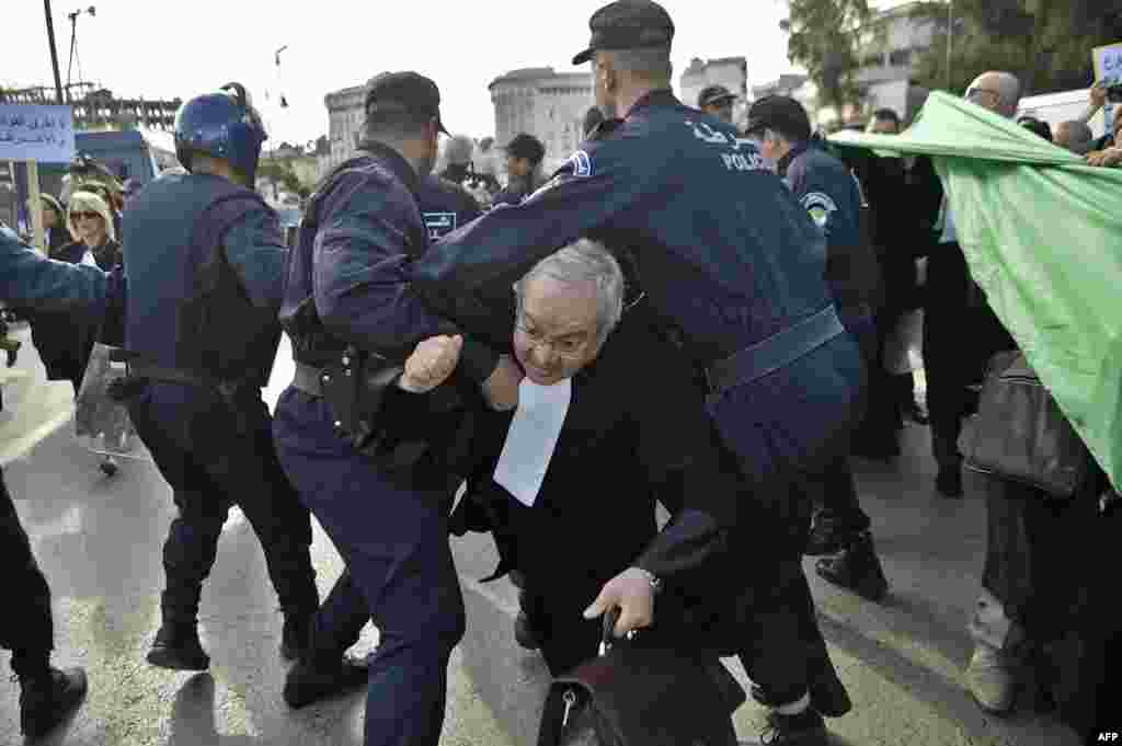 Algerian police disperse a protest by lawyers and journalists against their ailing president&#39;s bid for a fifth term in power, in Algiers.