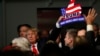 Republican presidential candidate, businessman Donald Trump, holds one of his signs after a rally coinciding with Pearl Harbor Day at Patriots Point aboard the aircraft carrier USS Yorktown in Mt. Pleasant, S.C., Monday, Dec. 7, 2015.