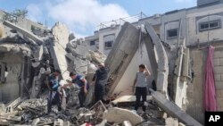 Palestinianos em meio aos escombros após um ataque aéreo israelita em Rafah, na Faixa de Gaza. Segunda-feira, 29 de abril de 2024. (AP Photo/Mohammad Jahjouh)