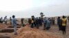 FILE - Officials and residents stand near freshly dug graves on June 11, 2019, in the Dogon village of Sobane-Kou, Mali, after an attack that killed dozens of ethnic Dogon on June 9, 2019. The mayor of a neighboring town blamed a Fulani militia group.