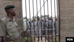 A corrections officer looks on as inmates gather near housing units at Naivasha Maximum Prison in Kenya, October 2014. (Gabe Joselow/VOA) 
