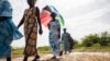 FILE - Women walk on farmlands that were destroyed by high salt content due to rising sea levels in Saloum Delta, Diamniadio Island in Senegal. 