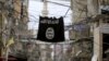 FILE - An Islamic State flag hangs amid electric wires, Jan. 19, 2016. 