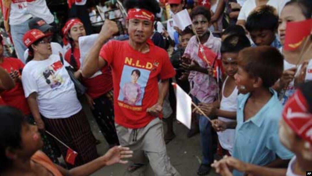 A man wearing a T-shirt bearing the image of Aung San Suu Kyi dances at campaign rally for the pro-democracy icon and her National League for Democracy, Rangoon, Burma, March 30, 2012. 