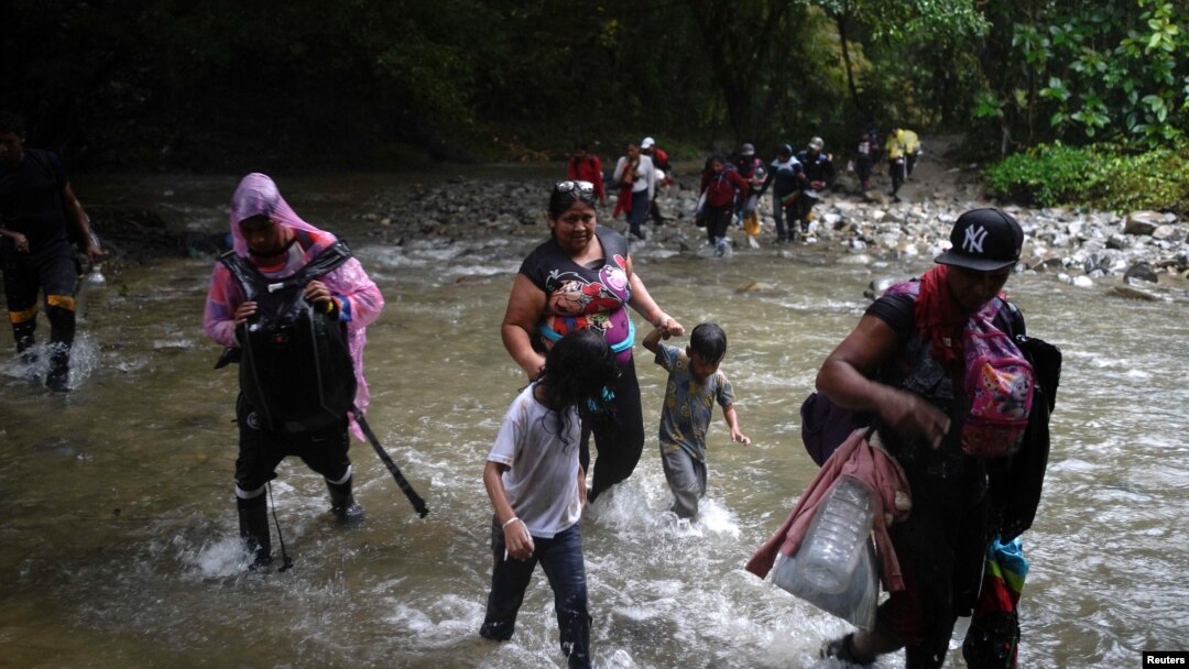 Migrantes caminan con niños en su viaje hacia la frontera con Estados Unidos, en Acandi, Colombia, el 9 de julio de 2023.
