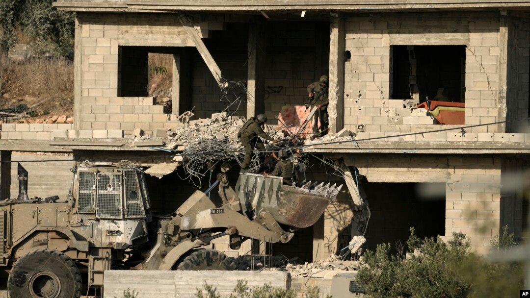 Fuerzas israelíes retiran el cuerpo de un hombre abatido en un operativo en Qabatiya, Margen Occidental, el 13 de junio del 2024.