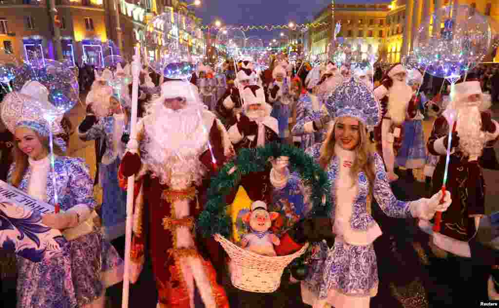 People dressed as Father Frost and Snow Maiden take part in a march on Christmas Eve in center of Minsk, Belarus.