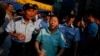 Police escort an anti-Occupy Central supporter to leave an area to prevent a confrontation with pro-democracy protesters inside a tent, which is block a main road at Hong Kong's Mongkok shopping district, Oct. 8, 2014. 
