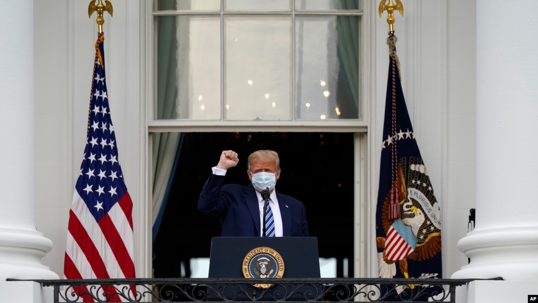 El presidente Donald Trump llega al balcón del Salón Azul de la Casa Blanca para hablar a una multitud de partidarios, el sábado 10 de octubre de 2020.