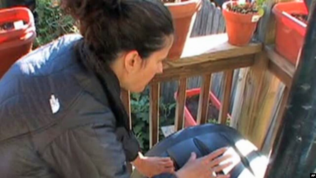 Once a day, Christiana Aretta spins the compost bin on her small apartment porch in Washington, D.C..