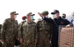 Turkey's Defense Minister Hulusi Akar, right, and top army commanders check the Turkey-Iran border in Van, eastern Turkey, Aug. 15, 2021.