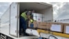 A Zimbabwe health official transfers donated Sinopharm COVID-19 vaccine into a government truck, at Robert Gabriel Mugabe International Airport, Feb. 15, 2021. China donated 200,000 Sinopharm doses to Cameroon on April 11, 2021. (Columbus Mavhunga/VOA)