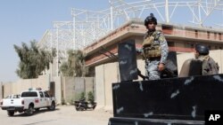 Iraqi security forces guard the entrance to a sports complex being built by a Turkish construction company, in the Shiite district of Sadr City, Baghdad, Iraq, Wednesday, Sept. 2, 2015.