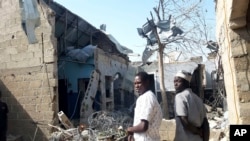 FILE - People gather at the scene of an explosion in Maiduguri, Nigeria, Dec. 23, 2021.