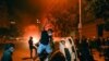 Manifestantes vandalizan un automóvil durante protestas por la muerte de George Flyod, el domingo 31 de mayo de 2020 en Washington, D.C.