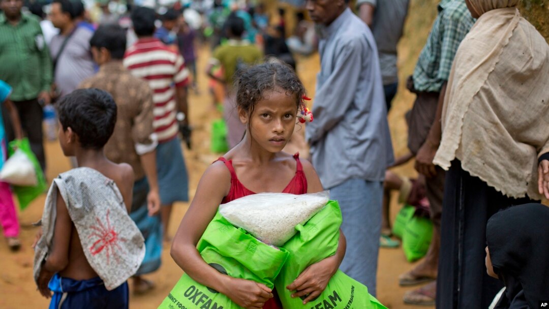A newly arrived Rohingya girl carries food rations in Kutupalong, Bangladesh, Saturday, Sept. 30, 2017. 