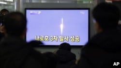 South Koreans watch a television broadcast reporting the country's first rocket launch at Seoul Railway Station in Seoul, South Korea, January 30, 2013.