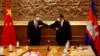 Chinese Foreign Minister Wang Yi, left, greets with Cambodian counterpart Prak Sokhonn in Phnom Penh, Cambodia, Sept. 12, 2021.