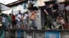 Агент Филиппинского агентства по борьбе с наркотиками (PDEA) сопровождает подозреваемых во время рейда в Маниле. 16 марта 2017