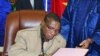 Guinean junta chief Captain Camara signs a pact on 15 Jan 2010 in Ouagadougou during a meeting with interim junta chief General Sekouba Konate and Burkina Faso President Blaise Compaore