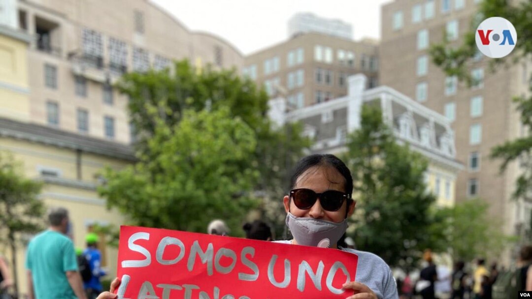 Una mujer hispana participa en las recientes protestas civiles en EE.UU., durante las cuales se puso a un lado el distanciamieno social.