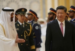 Sheikh Mohamed bin Zayed Al Nahyan, Crown Prince of Abu Dhabi, left, gestures to Chinese President Xi Jinping, right, after reviewing the Guard of Honor, at the Presidential Palace, July 20, 2018.