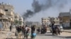 FILE - Palestinians displaced from shelters in Beit Hanoun cross the main Salaheddine road into Jabalia in the northern Gaza Strip, Nov. 12, 2024.