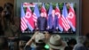 People watch a TV screen showing U.S. President Donald Trump, right, meeting with North Korean leader Kim Jong Un in Singapore during a news program at the Seoul Railway Station in Seoul, South Korea, June 12, 2018.
