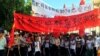 FILE - Villagers carry banners reading "Pleading with the central government to help Wukan" and "Wukan villagers don't believe Lin Zulian took bribes" during a protest in Wukan, in China's Guangdong province, on June 22, 2016. 