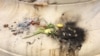 Items left at an impromptu memorial in Washington for slain Muslim teen Nabra Hassanen were set on fire, June 21, 2017. (E. Sarai/VOA)