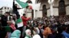 FILE - People carry national flags and banners during a protest calling on President Abdelaziz Bouteflika to quit, in Algiers, Algeria, March 26, 2019. 
