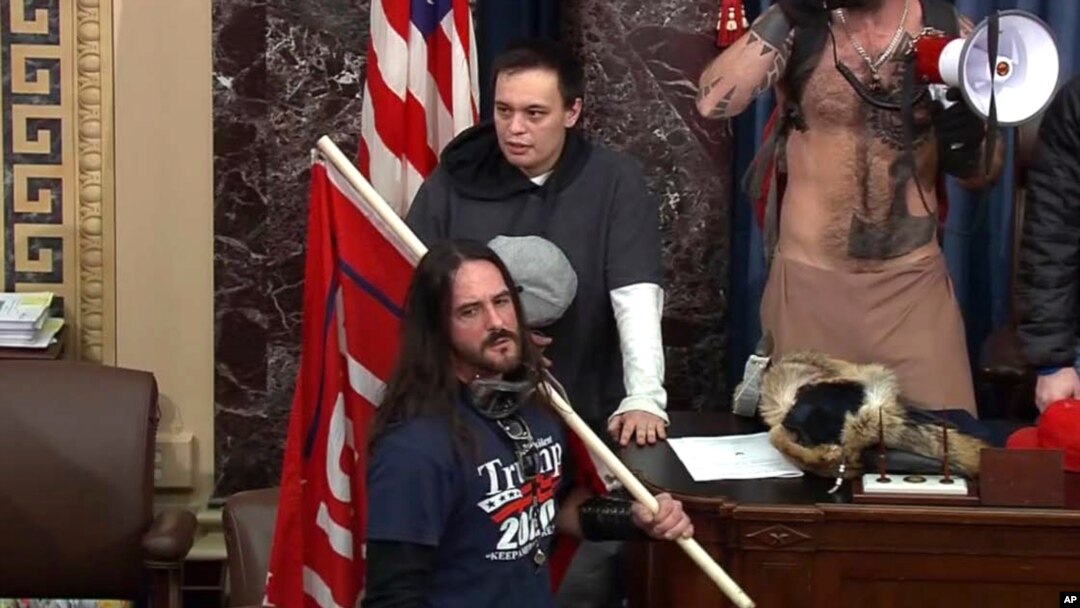 En esta imagen de archivo del video de la Policía del Capitolio, Paul Allard Hodgkins, de 38 años, de Tampa, Florida, al frente, está parado en el piso del Senado, el 6 de enero de 2021, en Washington DC.