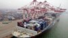 A cargo ship loaded with containers is seen anchored at a port in Qingdao, Shandong province, China, July 10, 2013.